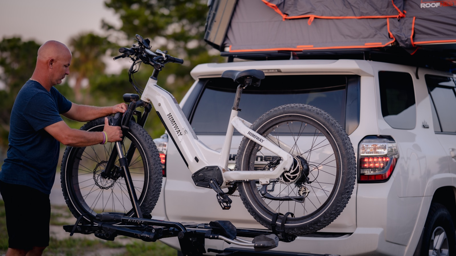 a man putting a bike on the back of a truck